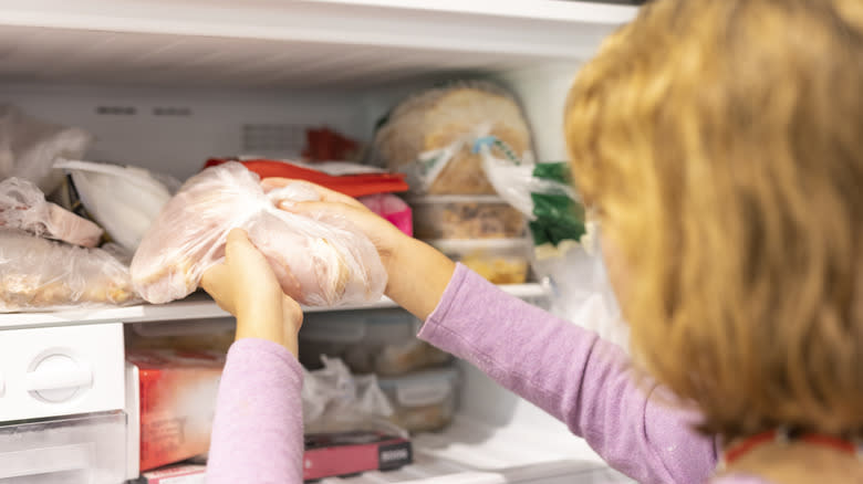 person removing freezer items