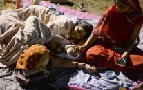 Indian residents rest and sleep in a football field in Siliguri