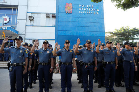 Policemen swear allegiance to the Philippine Constitution during a flag-raising ceremony at the grounds of Station 6, Batasan Police Station, in Quezon City, Metro Manila, Philippines December 4, 2017. REUTERS/Erik De Castro