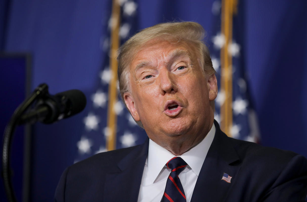 Donald Trump stands at a microphone as he delivers a speech at a pharmaceutical manufacturing plant.