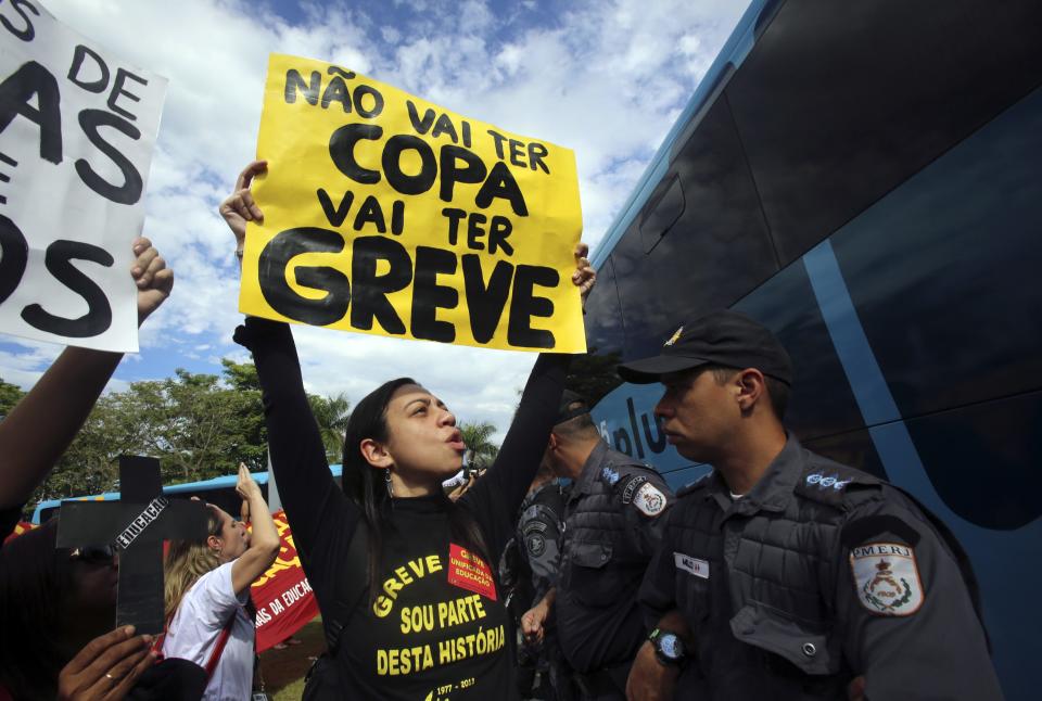 Teachers shout slogans as they protest against the 2014 World Cup outside a hotel where the Brazilian national soccer team are gathered, in Rio de Janeiro