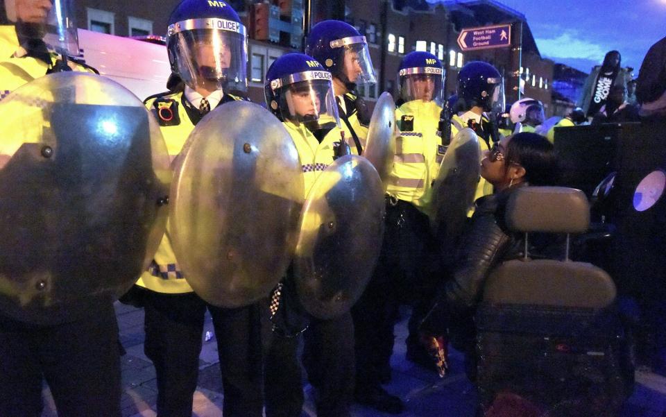 A woman stands at the police line in east London - Credit: Lauren Hurley/PA