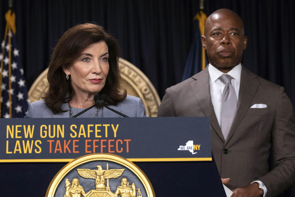 FILE - New York Gov. Kathy Hochul, left, and New York Mayor Eric Adams attend a news conference about the upcoming "Gun Free Zone" implementation at Times Square, Aug. 31, 2022, in New York. As tens of thousands of international migrants have arrived in New York City over the past year without jobs or a home, Adams and Hochul have begged President Joe Biden for one thing: Make it easier for migrants to get work authorization papers quickly. (AP Photo/Yuki Iwamura, File)