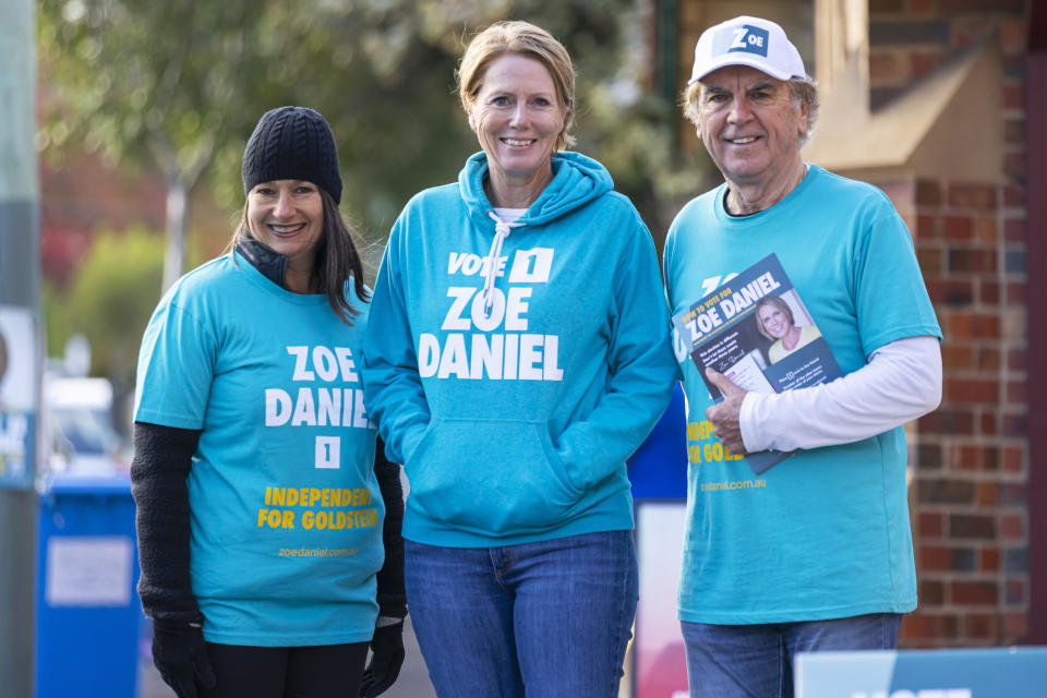 Independent candidate for Goldstein Zoe Daniel (centre) with a female and male supporter, all wearing teal campaign merchandise