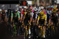 Denmark's Jonas Vingegaard, wearing the overall leader's yellow jersey, and Belgium's Wout Van Aert, wearing the best sprinter's green jersey, ride in the pack during the twenty-first stage of the Tour de France cycling race over 116 kilometers (72 miles) with start in Paris la Defense Arena and finish on the Champs Elysees in Paris, France, Sunday, July 24, 2022. (AP Photo/Daniel Cole)