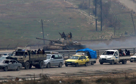 Forces loyal to Syria's President Bashar al-Assad sit on a tank as a convoy of buses and other vehicles bringing people out of eastern Aleppo turns back in the direction of the besieged rebel enclave, Syria December 16, 2016. REUTERS/Omar Sanadiki