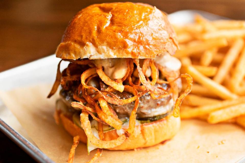 The burger at Neuse River Brewing in Raleigh is a “half pound beef patty with beer cheese, roasted garlic mustard aioli, house-made pickles, crispy onion strings served on a Union Special Bread brioche bun with a side of fries.”