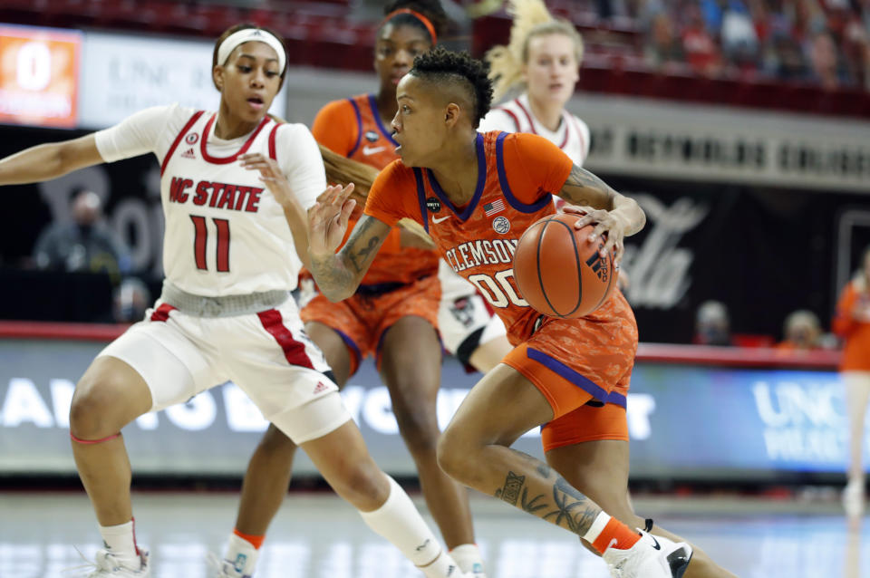 Clemson's Delicia Washington (00) drives around North Carolina State's Jakia Brown-Turner (11) during the first half of an NCAA college basketball game at Reynolds Coliseum in Raleigh, N.C., Thursday, Feb. 11, 2021. (Ethan Hyman/The News & Observer via AP)