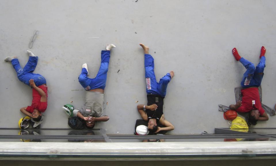 Construction workers take a nap on their lunch break inside the Arena Das Dunas stadium as work continues in preparation for the 2014 FIFA World Cup soccer championship in Natal December 13, 2013. The opening match in the 2014 World Cup will be held June 12. REUTERS/Gary Hershorn (BRAZIL - Tags: SPORT SOCCER WORLD CUP)