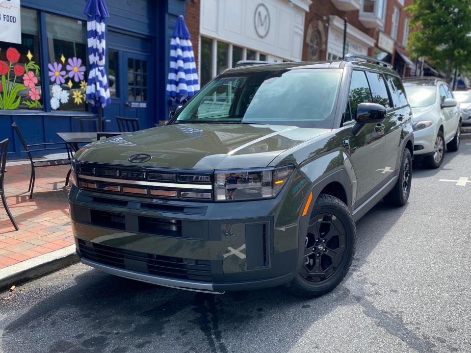 A green 2024 Hyundai Santa Fe XRT SUV is parked on a street.