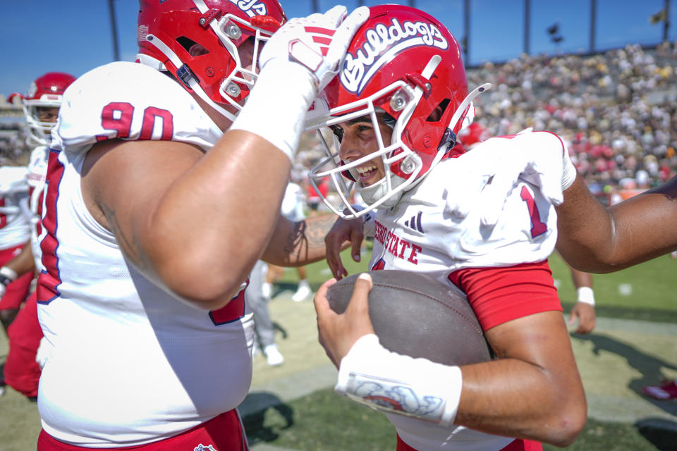 Fresno State's Mikey Keene (1) and Fresno State defensive lineman Dupre Mendoza (90) celebrate after winning an NCAA college football game over Purdue 38-35 in West Lafayette, Ind., Saturday, Sept. 2, 2023. (AP Photo/AJ Mast)