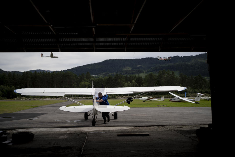 Garrett Fisher, an American aviator and adventurer, pushes his plane into Voss flyklubb's hangar in Voss, Norway, on Aug. 5, 2022. He is on a mission to photograph all the remaining glaciers that are not in the polar regions before they disappear. (AP Photo/Bram Janssen)
