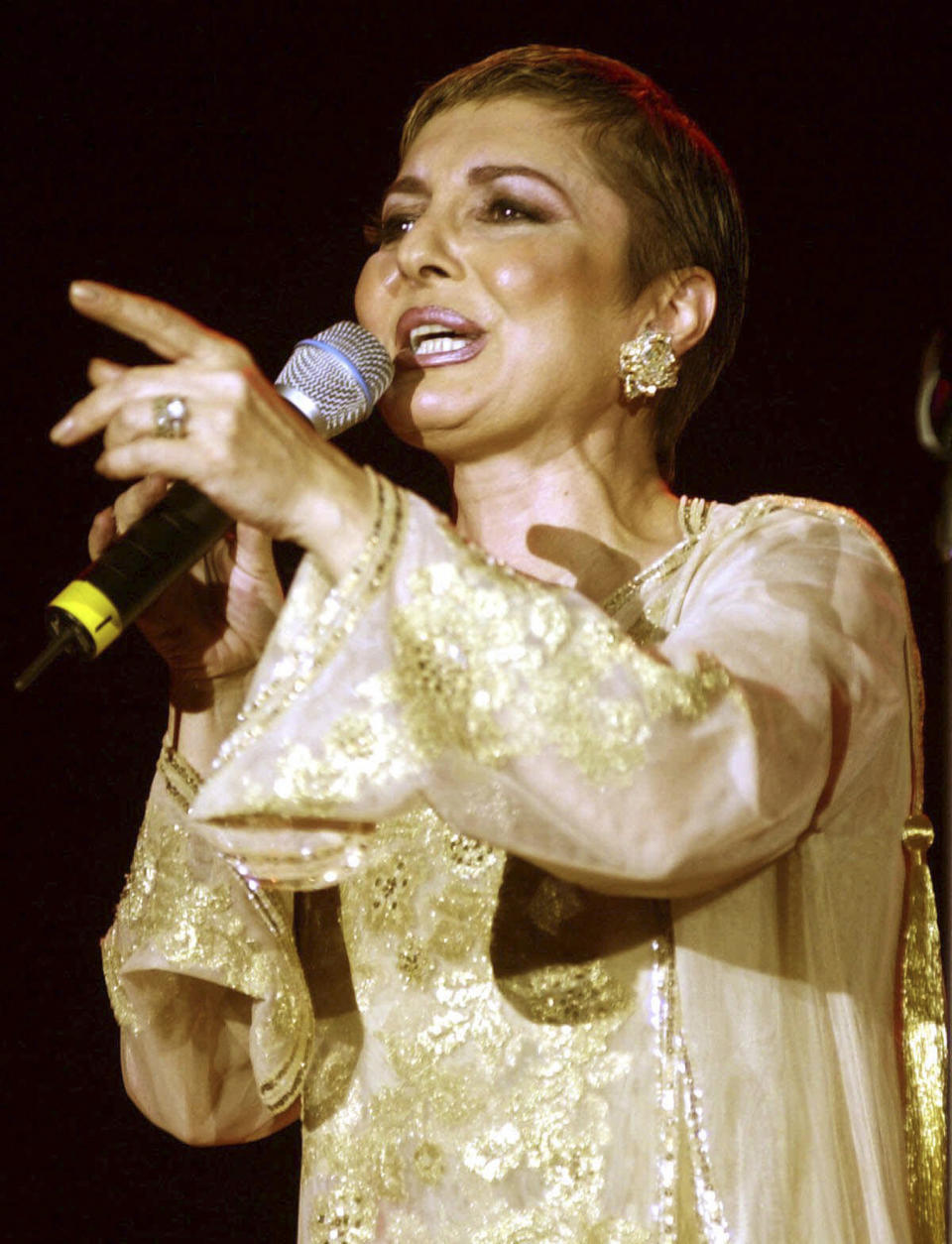 FILE - In this March 21, 2001 file photo Iranian pop star Googoosh performs during a concert in Dubai, United Arab Emirates. Googoosh has released a video that addresses homosexual love, a major gesture by one of the country's top cultural figures in exile, causing shockwaves in the Islamic republic. Googoosh sings "don’t tell me to stop loving: you can’t do that and I can’t either." Googoosh was Iran's first pop diva, though the 1979 revolution ended her live singing career for two decades until she immigrated to the West. Navid Akhavan, an Iranian-born German who wrote and directed the video for Googoosh’s song “Behesht” (Heaven), said it has been viewed by more than a million Iranians online or via illegal satellite channels since its Valentine’s Day release. (AP Photo/Kamran Jebreili, File)
