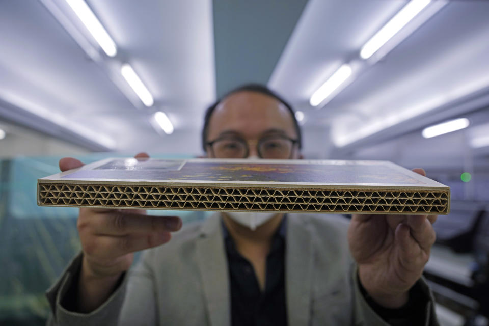 Wilson Tong, CEO of LifeArt Asia, shows a material sample of the cardboard coffin at Tong's factory in Hong Kong, Friday, March 18, 2022. Hong Kong is running short of coffins during its deadliest outbreak of the coronavirus pandemic, which has cost about 6,000 lives so far this year. LifeArt, a company in Hong Kong is trying to make an alternative, cardboard coffin, which it says is environmentally-friendly. (AP Photo/Kin Cheung)