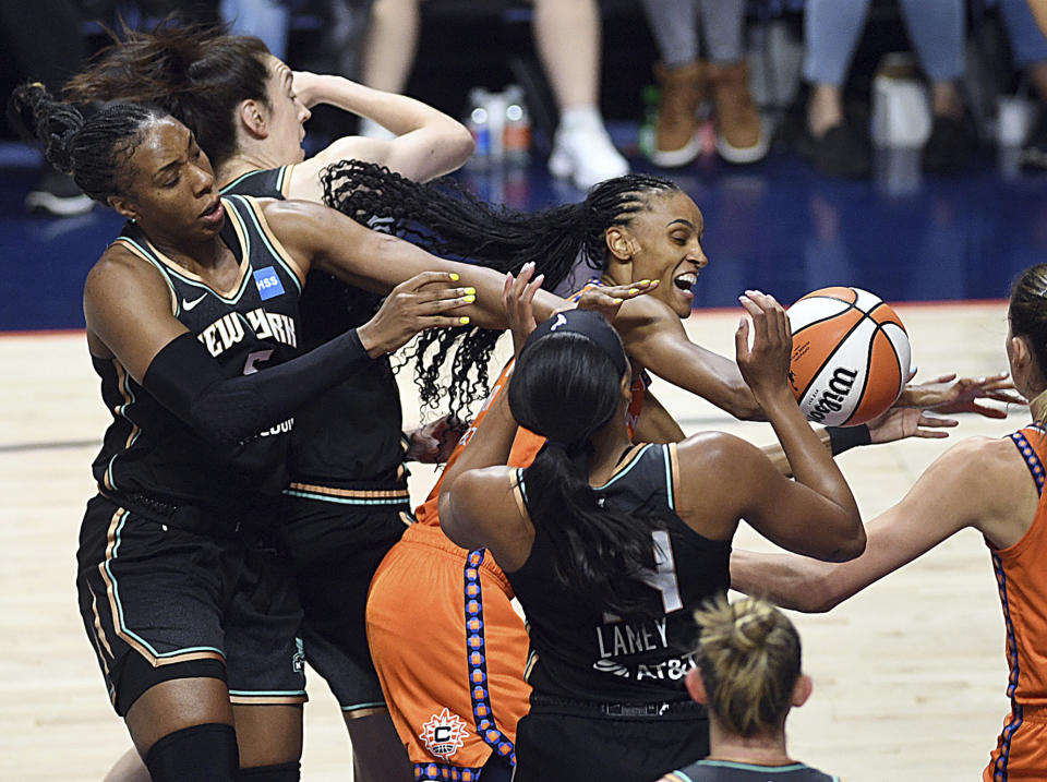 Connecticut Sun's DeWanna Bonner (24) competes against New York Liberty defenders for a rebound during a WNBA basketball game Thursday, Aug. 24, 2023, in Uncasville, Conn. (Sarah Gordon/The Day via AP)