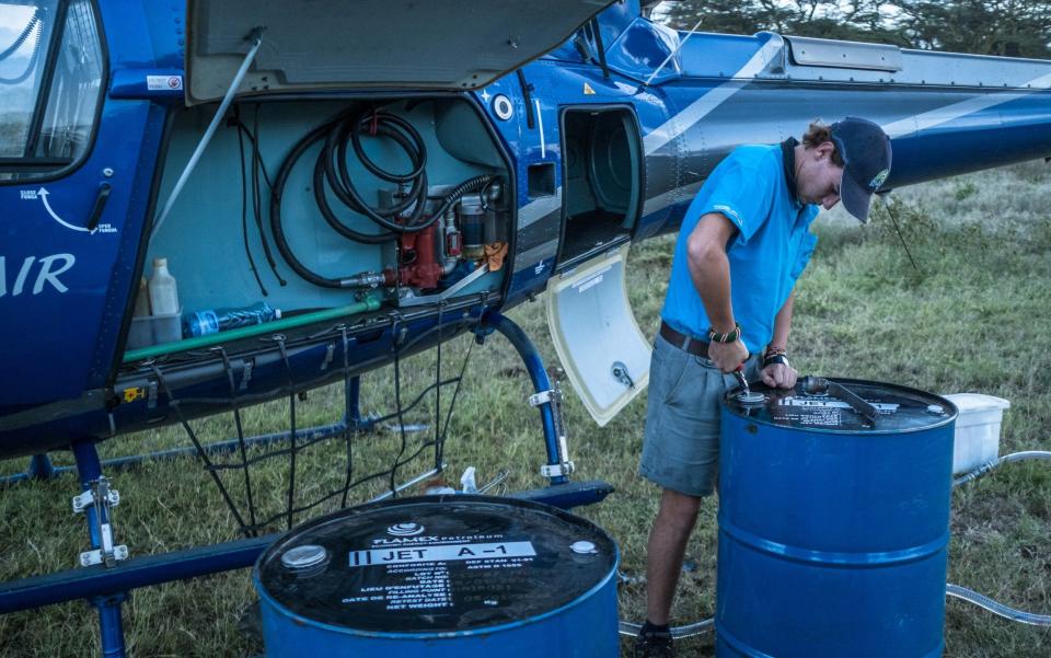 Max prepares to refuel a helicopter used for hunting swarms of locust - Brian Otieno