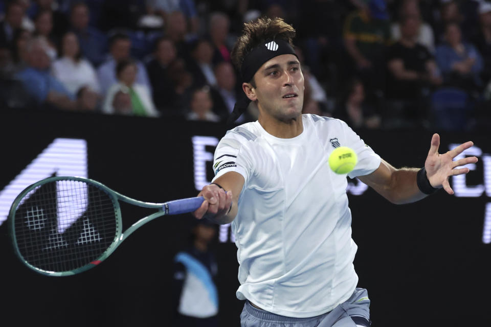 Tomas Martin Etcheverry of Argentina plays a forehand return to Novak Djokovic of Serbia during their third round match at the Australian Open tennis championships at Melbourne Park, Melbourne, Australia, Friday, Jan. 19, 2024. (AP Photo/Asanka Brendon Ratnayake)