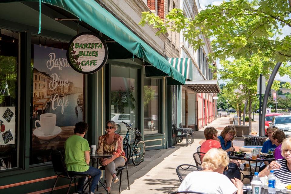 Women eat lunch and have coffee together outside of Barista Blues Cafe on Thursday, June 4, 2020 in Battle Creek, Mich.