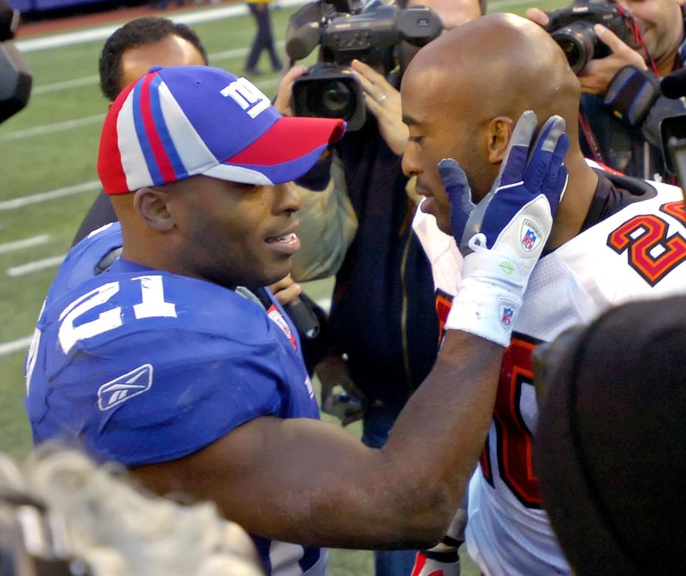 Giants back Tiki Barber, left, talks with twin brother, Buccaneers cornerback Ronde Barber, after their game in 2006.