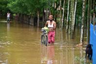 NAGAON,INDIA-JULY 22,2020 :Villagers wade through a flooded street at a flood affected area in Nagaon District of Assam, India - PHOTOGRAPH BY Anuwar Ali Hazarika / Barcroft Studios / Future Publishing (Photo credit should read Anuwar Ali Hazarika/Barcroft Media via Getty Images)