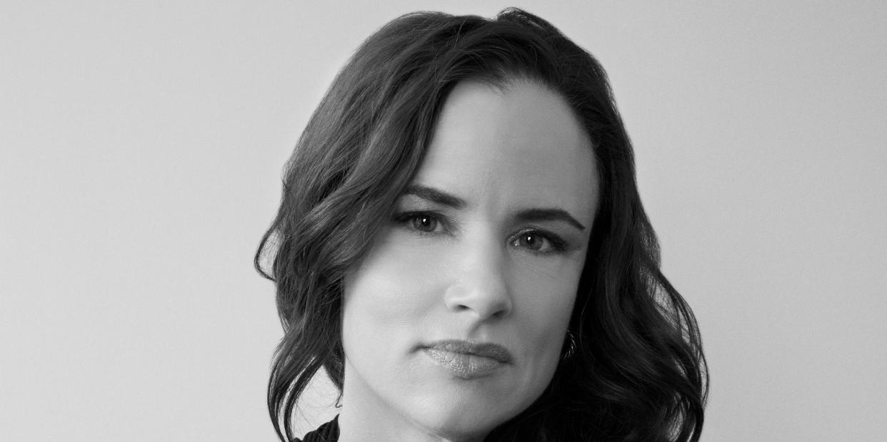 a black and white portrait of juliette lewis with her hair down wearing a black wrap neck dress