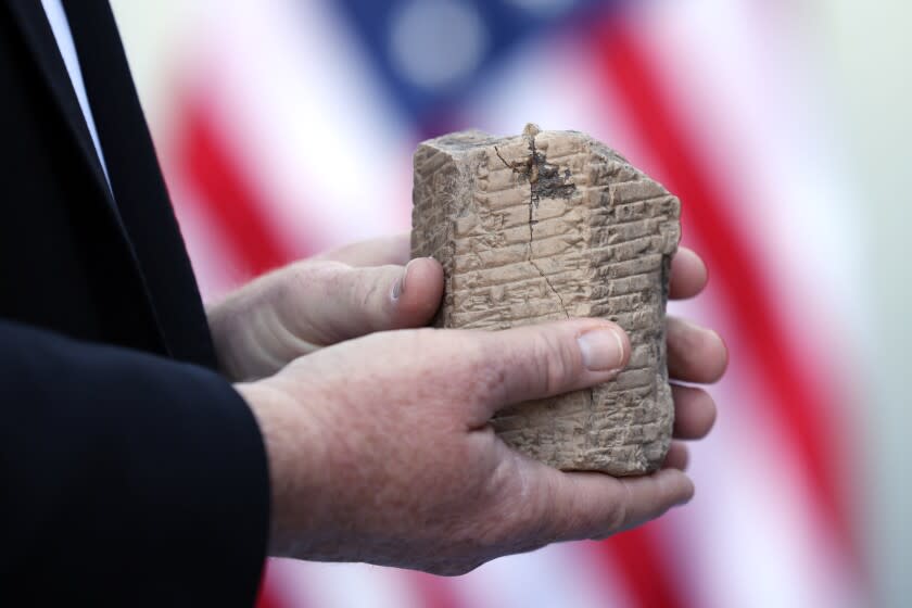 LOS ANGELES, CA - JANUARY 20: Homeland Security Agent with Investigations, Chad Fredrickson holds an ancient cuneiform prism during a ceremony where it and another ancient artifact were returned to the Iraqi government at Iraqi Consulate on Thursday, Jan. 20, 2022 in Los Angeles, CA. Fredrickson was on the team of those responsible for the return of the artifacts. (Dania Maxwell / Los Angeles Times)