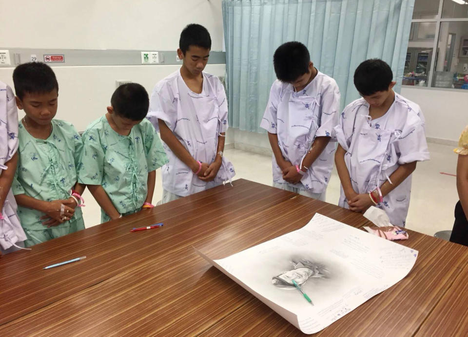 Some of the members of the soccer team bow their heads in front a picture of Saman. Source: AAP