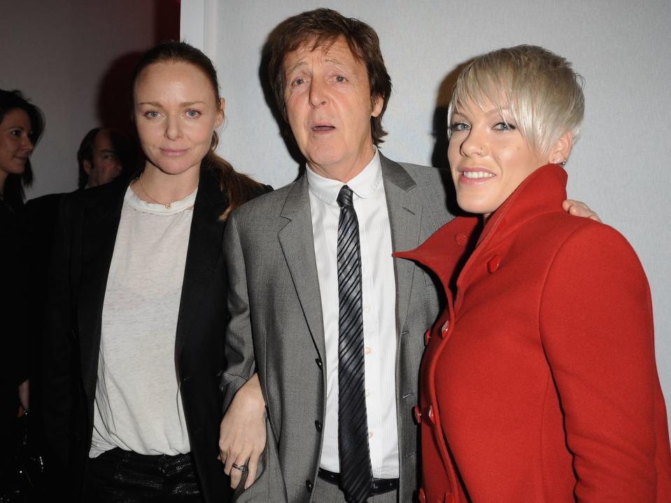 Sie kann aber auch "hochmodisch": Pink mal ungewohnt einfarbig in rot - neben Designer Stella McCartney und deren Vater, Ex-Beatle Paul McCartney.