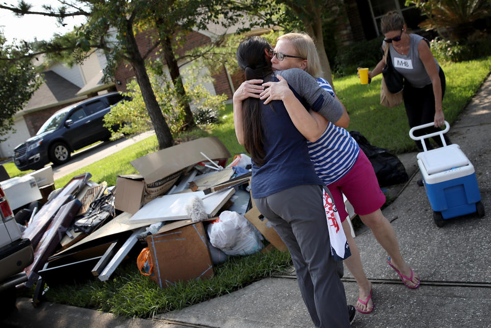 A Dickinson resident hugs a friend who came to help her remove possessions damaged due to flooding.