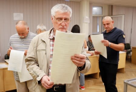 Voters look through their ballots at a polling station during a parliamentary election in Kiev