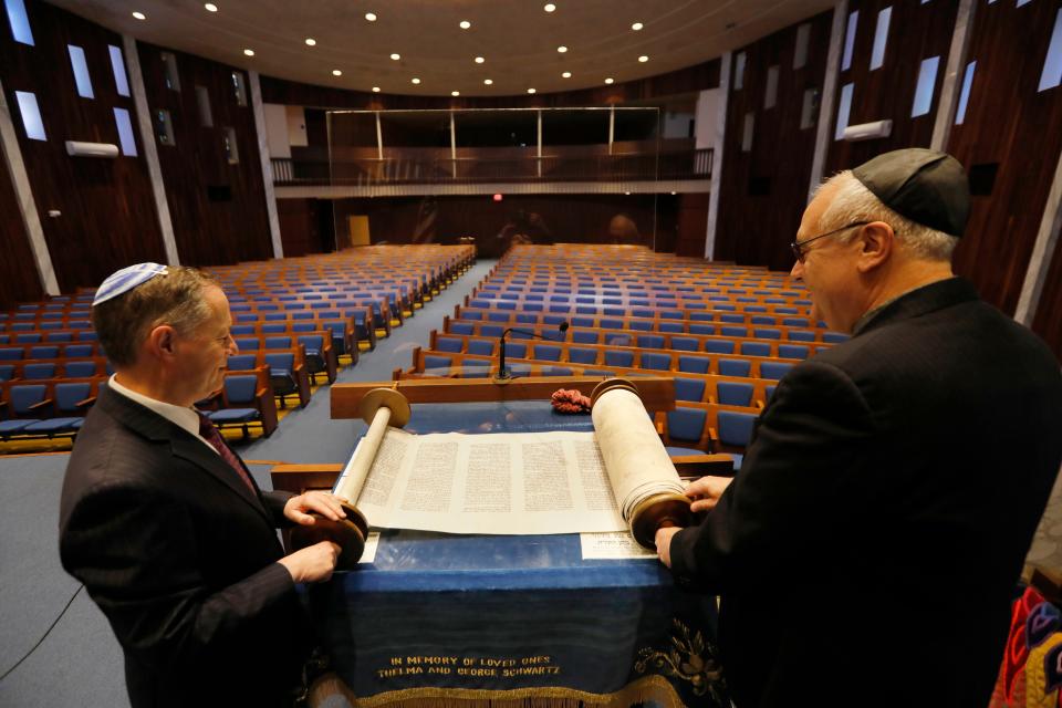 Rabbi Raphael Kanter and Congregation President Martin Levin open one of the old Torahs at the Tifereth Israel Synagogue on Brownell Avenue in New Bedford, which is celebrating its 100th anniversary.