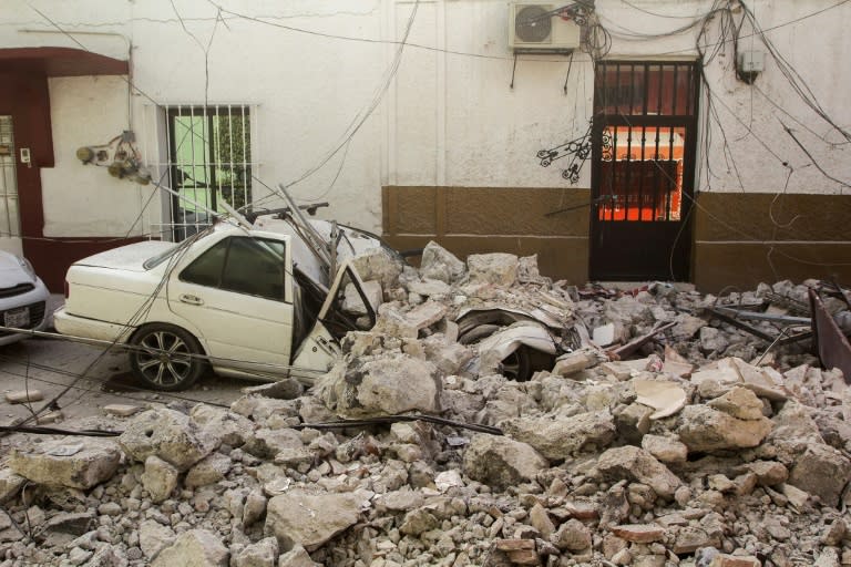 A car is crushed by debris from damaged houses in Jojutla de Juarez