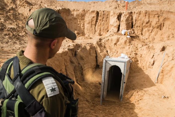 An Israeli officer walks near the entrance of a cross-border tunnel that Israel says was dug by the Islamic Jihad group from the Gaza Strip, on January 18, 2018 (AFP Photo/JACK GUEZ)