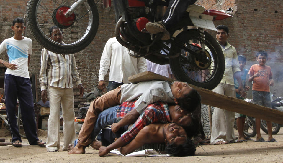 Hindu devotees perform a stunt during a rehearsal for the 134th annual Rath Yatra, or chariot procession in the western Indian city of Ahmedabad June 28, 2011. The annual religious procession, which will be held on July 3, commemorates a journey by Hindu god Jagannath, his brother Balabhadra and sister Subhadra, in specially made chariots. REUTERS/Amit Dave