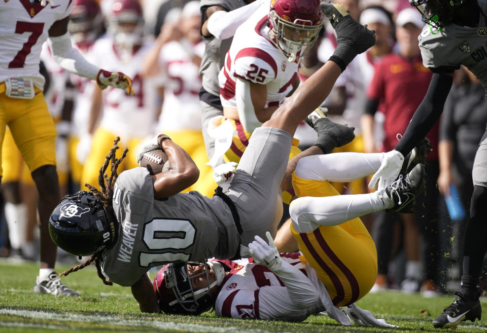 Southern California safety Bryson Shaw, bottom, pulls down Colorado wide receiver Xavier Weaver after he pulled in a pass in the first half of an NCAA college football game, Saturday, Sept. 30, 2023, in Boulder, Colo. (AP Photo/David Zalubowski)