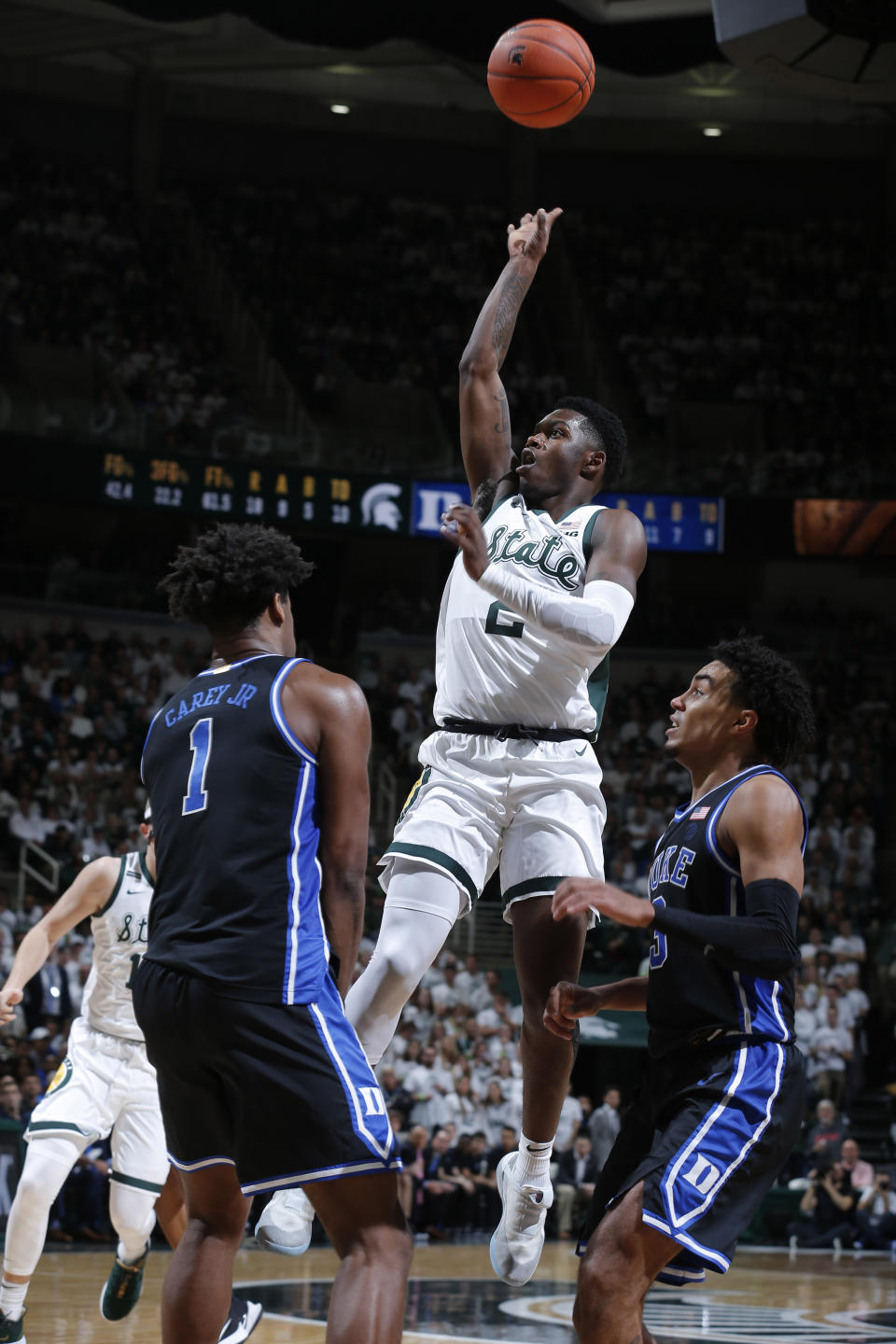 Michigan State's Rocket Watts, center, puts up a shot against Duke's Vernon Carey Jr., left, and Tre Jones, right, during the second half of an NCAA college basketball game, Tuesday, Dec. 3, 2019, in East Lansing, Mich. (AP Photo/Al Goldis)