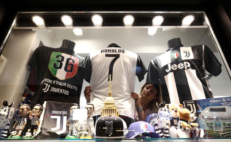 A picture taken on July 11, 2018 shows a saleswoman making the shop window with a Cristiano Ronaldo Juventus jersey in a shop in Turin. (Getty Images)