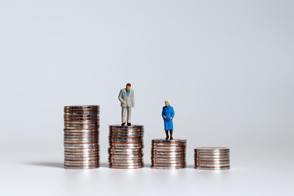 An old age miniature man and woman standing on a pile of coins. About 38 per cent of healthy senior men see a specialist, compared to just 30 per cent of healthy senior women in Canada. (Getty)