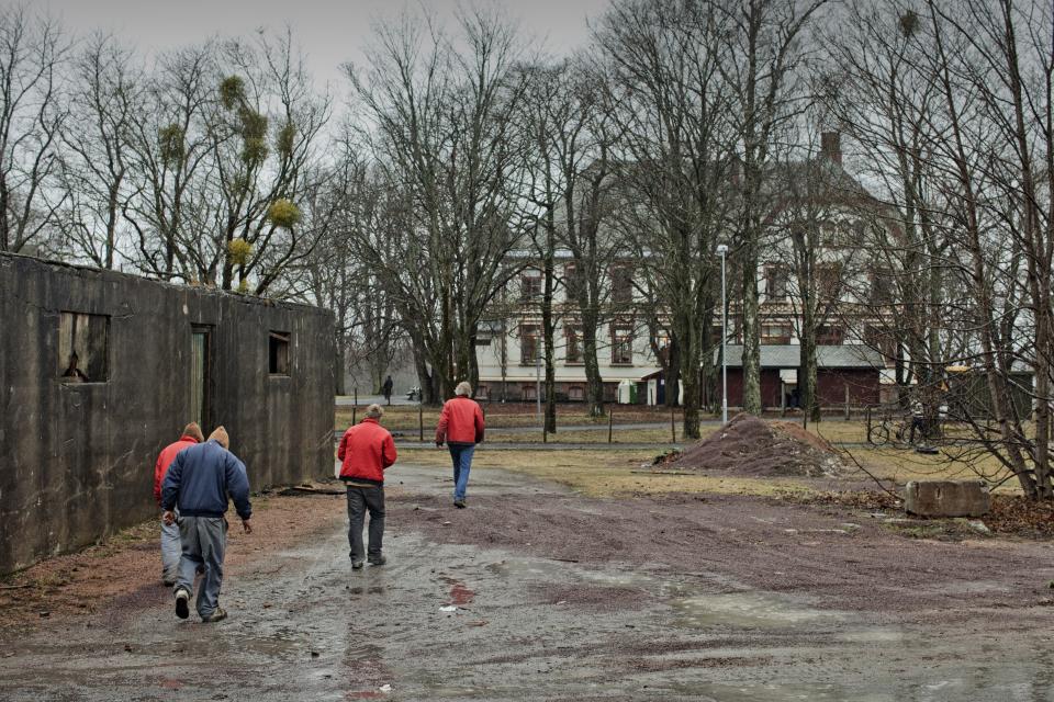 BASTOY ISLAND, HORTEN, NORWAY - APRIL 12:  Inmates walk away from the shops where the work as they finish their working duties in Bastoy Prison on April 12, 2011 in Bastoy Island, Norway. Bastoy Prison is a minimum security prison located on Bastoy Island, Horten, Norway, about 75 kilometers (46 mi) south of Oslo. The facility is located on a 2.6 square kilometer (1 sq mi) island and hosts 115 inmates. Arne Kvernvik Nilsen, governor of the prison, leads a staff of about 70 prison employees. Of this staff, only five employees remain on the island overnight.  Once a prison colony for young boys, the facility now is trying to become 'the first eco-human prison in the world.' Inmates are housed in wooden cottages and work the prison farm. During their free time, inmates have access to horseback riding, fishing, tennis, and cross-country skiing. (Photo by Marco Di Lauro/Reportage by Getty Images)