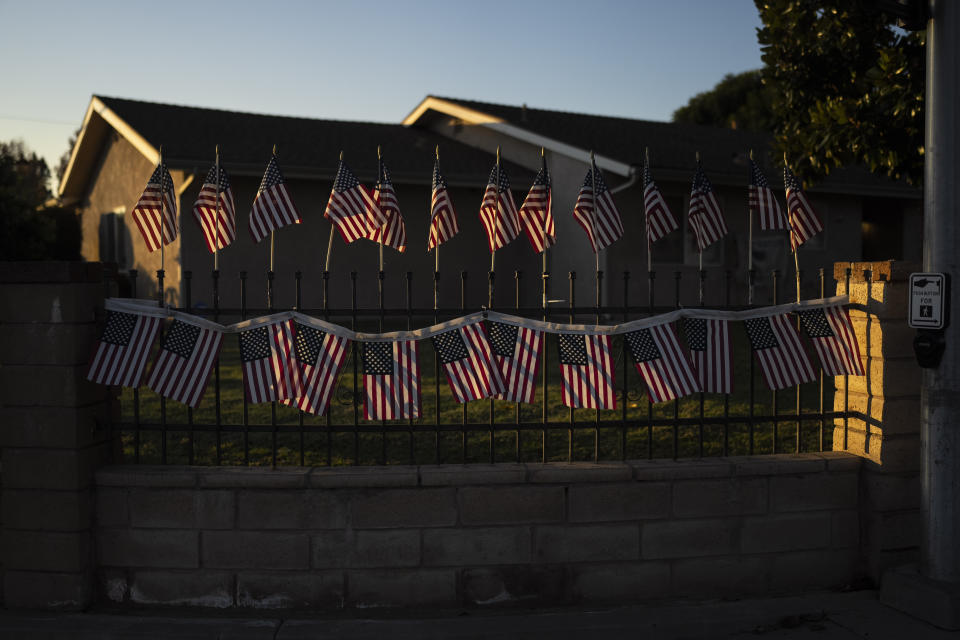 Pequeñas banderas estadounidenses adornan la barda de una vivienda en Chino, California, el jueves 8 de diciembre de 2022. (AP Foto/Jae C. Hong)