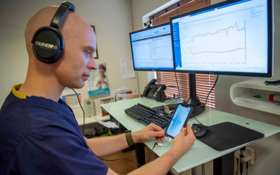 GP Dave Trisk viewing the app on his phone showing the readings from the new stethoscope which can be used between separate rooms. - Paul Grover