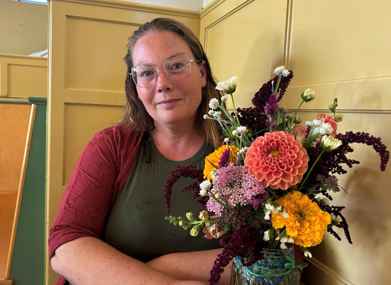 Gwendolyn Iris and her home blessing bouquet. This bouquet contains amaranth, marigolds, snapdragons, and zinnias, and is sealed with blue and green beeswax.