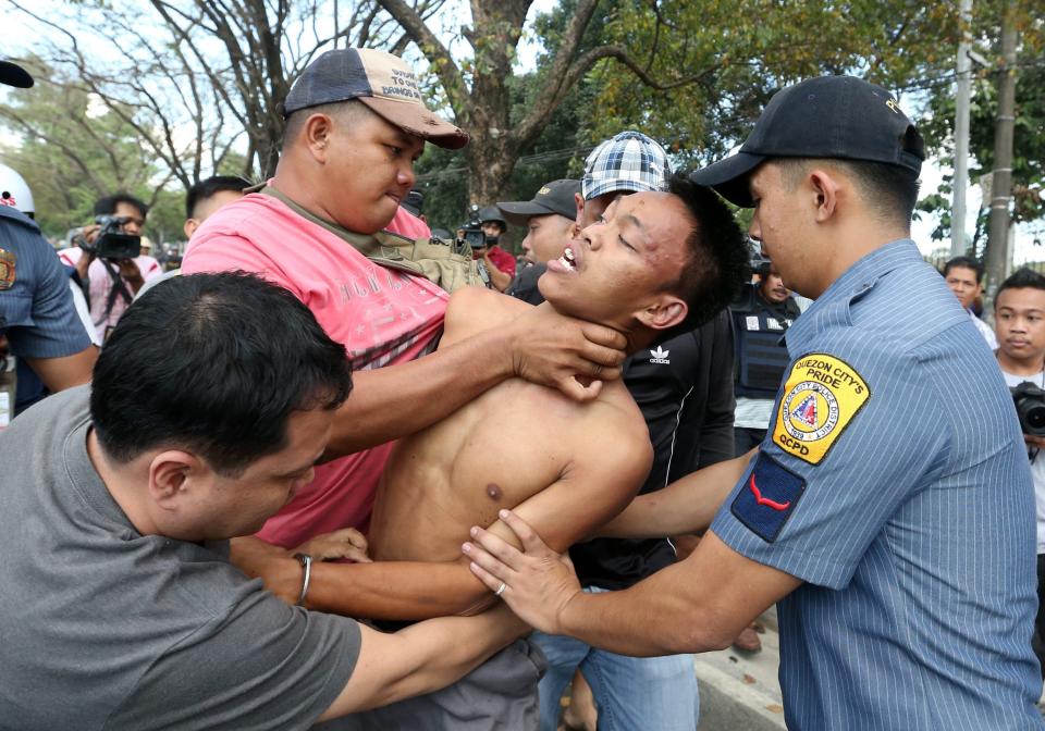 epaselect epa04044225 Filipino plainclothes policemen arrest an informal settler during a demolition of shanties at Sitio San Roque in Quezon City, east of Manila, Philippines, 27 January 2014. Throwing rocks, pillboxes, and even human waste, illegal settlers barricaded the demolition team in Baranggay Bagong Pag-asa. Four residents were arrested and twelve were reported injured. Residents report receiving cash from 300 to 450 US dollar in exchange for their voluntary relocation. Earlier, hundreds of the urban poor marched to the city hall in protest of the demolition that will pave the way for the rise of a business district. EPA/DENNIS M. SABANGAN