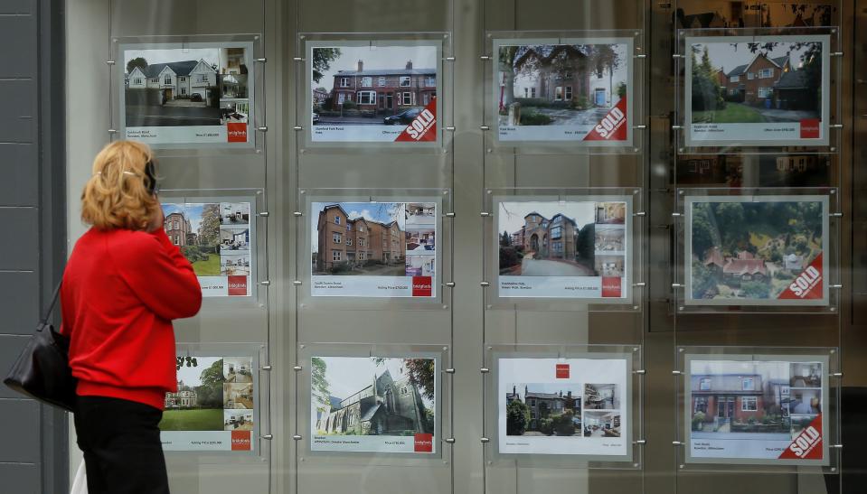 A woman looks at properties advertised for sale in the window of an estate agent in Hale, northern England July 3, 2013. REUTERS/Phil Noble