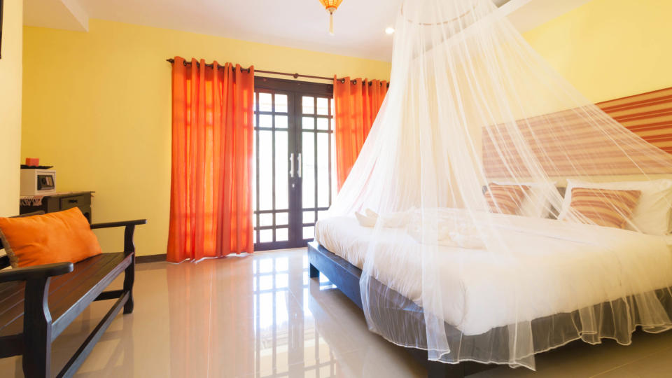 A bedroom with a mosquito net over the bed