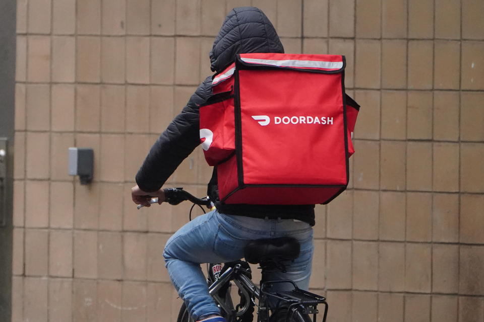 A delivery person for Doordash rides his bike in the rain during the coronavirus disease (COVID-19) pandemic in the Manhattan borough of New York City, New York, U.S., November 13, 2020. REUTERS/Carlo Allegri