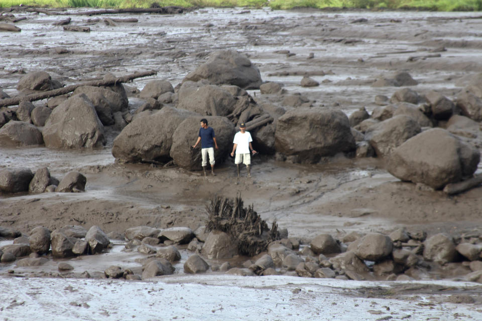 People inspect an area affected by flash flood in Agam, West Sumatra, Indonesia, Sunday, May 12, 2024. Heavy rains and torrents of cold lava and mud rushing down a volcano on Indonesia’s Sumatra island have triggered flash floods that killed more than a dozen of people and injured several others, officials said Sunday. (AP Photo/Ali Nayaka)