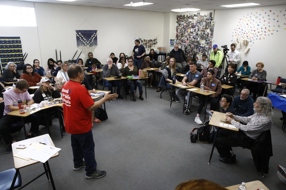 A precinct leader speaks with caucus-goers at a caucus location at Coronado High School in Henderson, Nev., Saturday, Feb. 22, 2020. (AP Photo/Patrick Semansky)