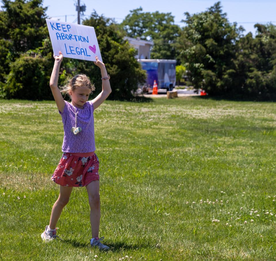 Eden Lupton, holds a sign up in the air “Keep Abortion Legal” at the Hyannis rotary on Saturday.