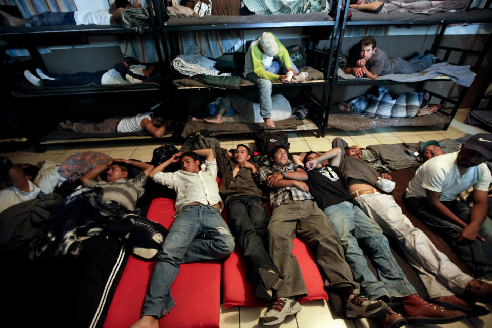 FILE - In this April 28, 2010 file photo, men look for a place to sleep in a crowded shelter for migrants deported from the United States, in the border city of Nogales, Mexico. The state of California is freeing up to $28 million to help asylum-seekers released in the U.S. with notices to appear in court with hotels, medical screenings, and transportation. California's generosity is a stark contrast to Arizona and Texas, where border state officials have challenged and sharply criticized President Joe Biden's immigration policies. (AP Photo/Gregory Bull,File)